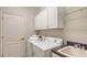 Functional laundry room with sink, overhead cabinets, and appliances at 14404 Stirling Dr, Lakewood Ranch, FL 34202