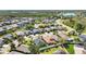 A beautiful aerial view of a residential community with manicured lawns, lush trees, and a serene lake nearby at 16620 Fairbolt Way, Odessa, FL 33556