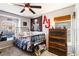 Decorated bedroom with ceiling fan, a full bed, window, and wall decor at 16620 Fairbolt Way, Odessa, FL 33556