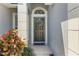 Welcoming front door with decorative wreath, complemented by colorful plants and a 'hello' mat at 16620 Fairbolt Way, Odessa, FL 33556