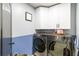 Convenient laundry room with modern washer and dryer and ample cabinet storage at 16620 Fairbolt Way, Odessa, FL 33556