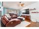 Comfortable living room featuring a leather sectional, ceiling fan, and bright natural light at 16620 Fairbolt Way, Odessa, FL 33556