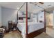 Bright main bedroom with a four-poster bed, ceiling fan, and cozy carpeting at 16620 Fairbolt Way, Odessa, FL 33556