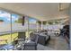 Screened patio features comfortable seating area and view of the green backyard, perfect for outdoor living at 16620 Fairbolt Way, Odessa, FL 33556