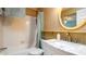 Cozy bathroom featuring a shower/tub combination, a sink, and a decorative round mirror at 1770 Lake Pl # 1770D, Venice, FL 34293