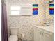 Cozy bathroom featuring colorful wallpaper, a single sink vanity, a window with blinds, and a shower at 1770 Lake Pl # 1770D, Venice, FL 34293