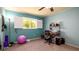 Bright bedroom featuring blue walls, carpeted floors, window with shutters, and a ceiling fan at 1770 Lake Pl # 1770D, Venice, FL 34293