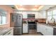 Well-lit kitchen featuring stainless steel appliances, white cabinetry, and countertop space at 1770 Lake Pl # 1770D, Venice, FL 34293