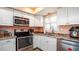 Well-equipped kitchen featuring white cabinetry, stainless steel appliances, and a modern sink at 1770 Lake Pl # 1770D, Venice, FL 34293