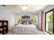Bright main bedroom boasts an exterior door, windows with shutters, and a ceiling fan at 1770 Lake Pl # 1770D, Venice, FL 34293
