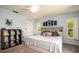 Bright main bedroom with soft carpet, a decorative headboard, natural lighting, and a ceiling fan at 1770 Lake Pl # 1770D, Venice, FL 34293