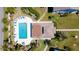 Aerial view of sparkling community pool with lounge chairs, landscaped grounds, and a sunny setting at 1770 Lake Pl # 1770D, Venice, FL 34293