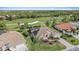 Aerial view showcasing a home with solar panels and proximity to a golf course at 1975 White Feather Ln, Nokomis, FL 34275
