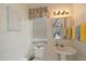 Small bathroom includes a toilet, sink, neutral wallpaper, and window at 1975 White Feather Ln, Nokomis, FL 34275
