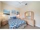 Bright bedroom features beach-themed art, a ceiling fan, and a cozy bed with a blue and white seashell pattern at 1975 White Feather Ln, Nokomis, FL 34275