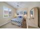 This bedroom offers a large window with natural light, ceiling fan, and calming beach themed decorative artwork at 1975 White Feather Ln, Nokomis, FL 34275