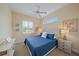 This bedroom is decorated with a ceiling fan, coastal themed wall art, and a window with plantation shutters at 1975 White Feather Ln, Nokomis, FL 34275