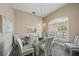 Formal dining room features a glass-top table with seating for six, a chandelier, and natural light at 1975 White Feather Ln, Nokomis, FL 34275