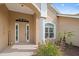 Home featuring a tiled front porch, well-maintained landscaping, and a welcoming front door with sidelights at 1975 White Feather Ln, Nokomis, FL 34275
