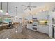 Bright kitchen featuring white cabinets, granite countertops, and modern appliances open to living area at 1975 White Feather Ln, Nokomis, FL 34275