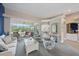 Bright living room with comfortable seating, light gray carpet, a statement wall, and access to other living areas at 1975 White Feather Ln, Nokomis, FL 34275