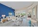 Bright living room features a blue accent wall, neutral furniture and view of the outdoor living space at 1975 White Feather Ln, Nokomis, FL 34275