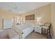 A traditionally styled main bedroom boasts soft carpeting and a king bed with white frame and palm patterned bedding at 1975 White Feather Ln, Nokomis, FL 34275