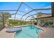 Beautiful pool and spa are surrounded by seating in a screened-in enclosure with landscaped views at 1975 White Feather Ln, Nokomis, FL 34275