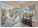 Bright sunroom leads to a screened-in lanai with pool and spa and lush landscaping beyond at 1975 White Feather Ln, Nokomis, FL 34275