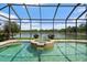 Screened-in pool area featuring a tranquil fountain and view of the gorgeous lake at 203 Winding River Trl, Bradenton, FL 34212
