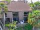 Lovely condo building featuring neutral tones, red tile roofing, and two stories with balcony overlooking lush landscaping at 212 Pass Key Rd # 212, Sarasota, FL 34242