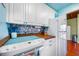 Bright kitchen with white cabinets, mosaic backsplash, and modern white appliances at 212 Pass Key Rd # 212, Sarasota, FL 34242