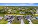 Aerial view showcasing homes in a neighborhood with lush trees, clear skies at 2302 Manheim Ave, North Port, FL 34286