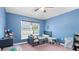 Light blue bedroom with a ceiling fan, window, twin bed, and plum-colored carpet at 2302 Manheim Ave, North Port, FL 34286