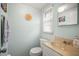 Compact bathroom featuring pale green walls, a single sink vanity, and a toilet, with natural light at 2620 White Sands Dr, Sarasota, FL 34231