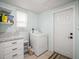Functional laundry area with a washer, white cabinets, and a window, offering convenience and storage at 2620 White Sands Dr, Sarasota, FL 34231