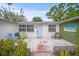 Cozy outdoor patio area with comfortable seating, a colorful door, and lovely landscaping at 2620 White Sands Dr, Sarasota, FL 34231