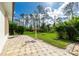 Paver patio overlooks the beautifully landscaped backyard, featuring mature trees and fire pit at 2629 Rolling Rd, North Port, FL 34288