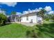 Landscaped backyard featuring a view of the home's screened-in lanai and green lawn at 2629 Rolling Rd, North Port, FL 34288
