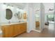Bathroom features double sink vanity with granite countertop, and large framed mirror at 2629 Rolling Rd, North Port, FL 34288