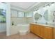 Bathroom with dual vanities, soaking tub and ample lighting at 2629 Rolling Rd, North Port, FL 34288