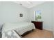 This bedroom features a neutral color palette, tile flooring and a window providing natural light at 2629 Rolling Rd, North Port, FL 34288