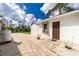 Rear exterior view of white house with brown door, surrounded by a well maintained yard at 2629 Rolling Rd, North Port, FL 34288