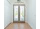 Bright foyer showcasing glass double doors, neutral tile flooring, and ample closet space, ideal for welcoming guests at 2629 Rolling Rd, North Port, FL 34288