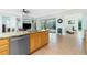 Open kitchen with stainless appliances, tile floors, and light wood cabinets at 2629 Rolling Rd, North Port, FL 34288