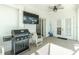 Covered patio area featuring an outdoor kitchen with a BBQ grill, television, and seating at 2629 Rolling Rd, North Port, FL 34288