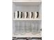 Organized kitchen cabinet featuring mugs and glasses on shelves, maximizing space with practical storage solutions at 2916 Woodcrest Dr, Sarasota, FL 34239