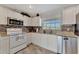 Modern kitchen with white cabinets, stainless steel appliances, and a tiled backsplash at 2916 Woodcrest Dr, Sarasota, FL 34239