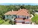 Stunning home featuring a red tile roof, lush landscaping, and a three-car garage at 3303 Sabal Cove Cir, Longboat Key, FL 34228