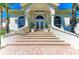Inviting entryway with brick stairs leading to double doors, complemented by potted plants and arched windows at 3303 Sabal Cove Cir, Longboat Key, FL 34228